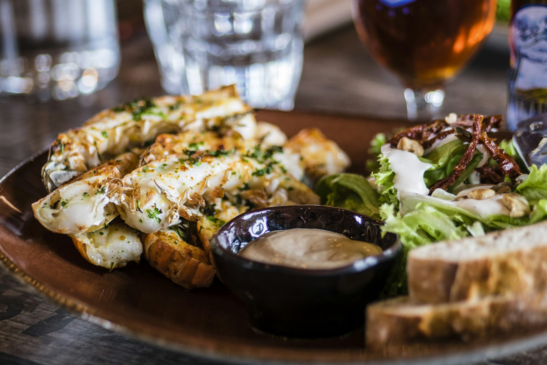 top down view of an elegant rustic wooden table featuring artisanal mediterranean dishes, roasted vegetables, artisanal bread, olive oil, sharp focus, food photography